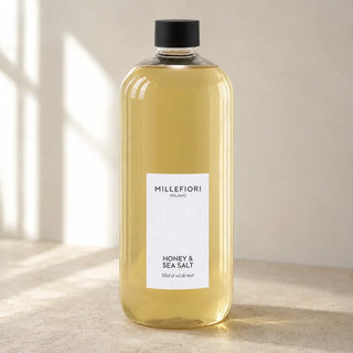 Detail van Milano Refill 500 ml Honey & Sea Salt van Millefiori met zwarte schroefdop, laag wit etiket en navulfles in zacht raamlicht.