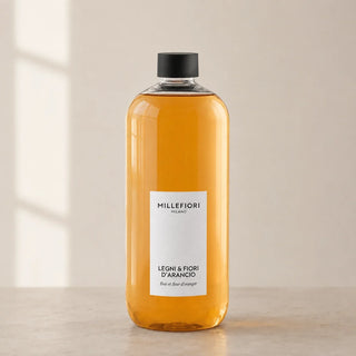 Detail van Milano Refill 500 ml Legni e Fiori dArancio van Millefiori met zwarte schroefdop, laag wit etiket en navulfles in zacht raamlicht.