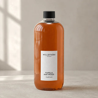 Detail van Milano Refill 500 ml Vanilla & Wood van Millefiori met zwarte schroefdop, laag wit etiket en navulfles in zacht raamlicht.