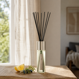 Millefiori Selected Mirto geurstokjes op hout met citrus en jeneverbes in natuurlijk raamlicht.