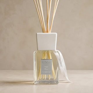 Detail van Millefiori Zona geurstokjes Aria Mediterranea 500ml met vierkante glazen flacon, witte kraag en bedrukte lintjes.
