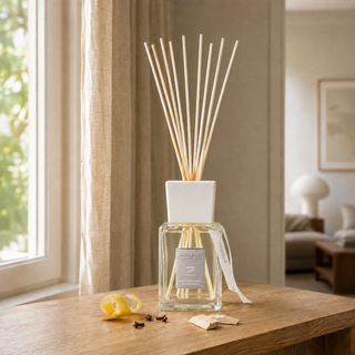 Millefiori Zona geurstokjes Aria Mediterranea 500ml op hout met citrus, kruidnagel en hout in natuurlijk raamlicht.