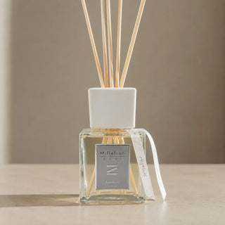 Detail van Millefiori Zona geurstokjes Keemun 250ml met vierkante glazen flacon, witte kraag en bedrukte lintjes.