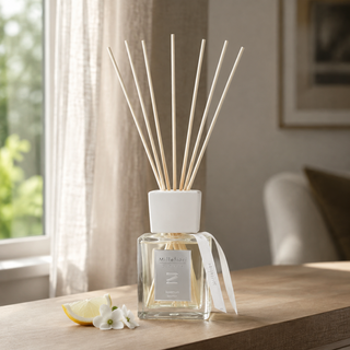 Millefiori Zona geurstokjes Keemun 250ml op hout met citrus en witte bloemen bij een Europees raam met linnen gordijn.