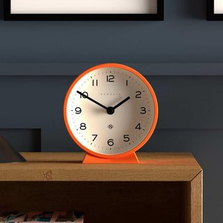 M tafelklok Echo oranje 16cm van Newgate, toegepast in een stijlvolle woonkamer