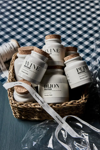 Dijon mosterd van Nicolas Vahe, in een culinaire setting met bijpassende ingrediënten, vanuit een tweede beeldhoek