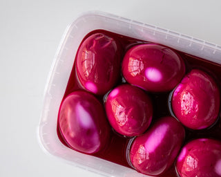 Hardgekookte eieren die roze kleuren in het vocht van rode biet