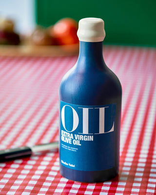 Blauwe fles Nicolas Vahé extra vierge olijfolie uit Griekenland op tafel