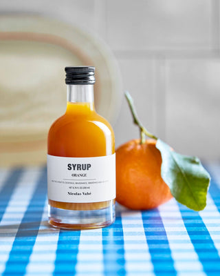 Fruitsiroop Sinaasappel – 200 ml van Nicolas Vahe, in een culinaire setting met bijpassende ingrediënten