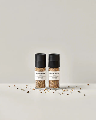 Geschenkdoos met gouden peper en zout mix van Nicolas Vahe, in een culinaire setting met bijpassende ingrediënten