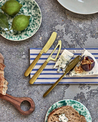 Kaas messen Cheese goud van Nicolas Vahe, in een culinaire setting met bijpassende ingrediënten