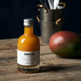 Nicolas Vahé mangoazijn van 200 ml met mango en bijpassende ingrediënten.