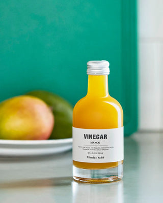 Mango azijn 200ml van Nicolas Vahe, gepresenteerd in een culinaire keuken- of tafelsetting