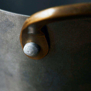 Close-up van een minibucket met gebogen handgreep en ronde klinknagel als bevestiging