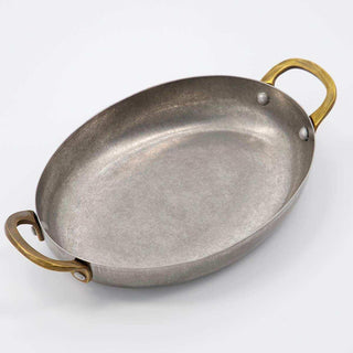 Ovale mini pan met goudkleurige handgrepen op een witte achtergrond