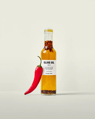 Olijfolie met chili 250ml van Nicolas Vahe, gepresenteerd in een culinaire keuken- of tafelsetting