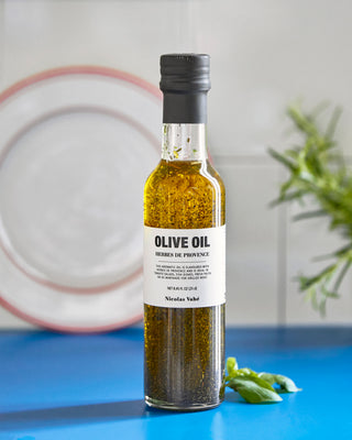 Olijfolie met provinciaalse kruiden 250ml van Nicolas Vahe, gepresenteerd in een culinaire keuken- of tafelsetting