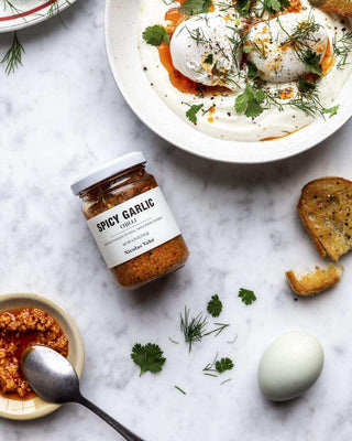 Pittige knoflook olie van Nicolas Vahe, in een culinaire setting met bijpassende ingrediënten
