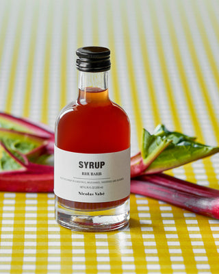 Fles Nicolas Vahé Rhubarb siroop naast verse rabarber