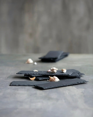 Serveerplank Slate Grijs 30x10cm van Nicolas Vahe, in een culinaire setting met bijpassende ingrediënten