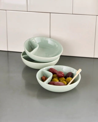 Serveerschaal Olive in mintgroen 12cm van Nicolas Vahe, in een culinaire setting met bijpassende ingrediënten
