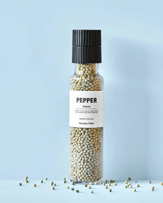 Nicolas Vahé molen met witte peper op een lichtblauwe ondergrond met losse peperkorrels