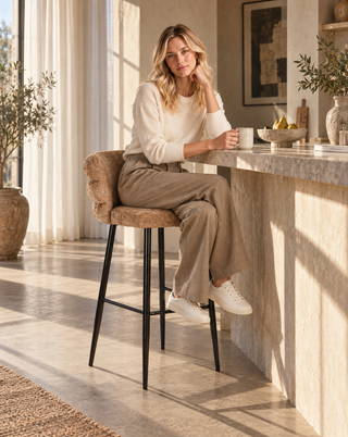 Nora zit op de Pole to Pole barstoel Cloud Caramel in een interieur