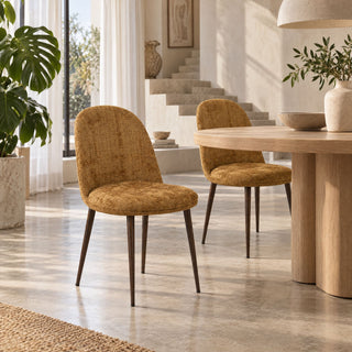 Twee goudkleurige Pole to Pole eetkamerstoelen Egg Gold bij een ronde houten eettafel