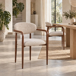 Twee Pole to Pole Sake eetkamerstoelen in Oatly met armleuningen naast een houten eettafel
