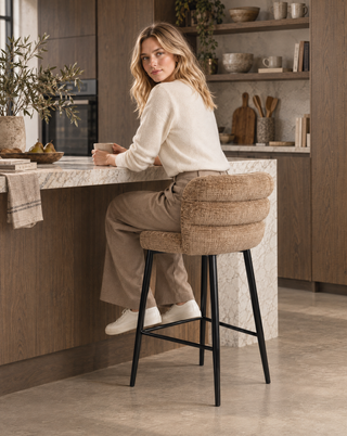 Nora zit op de Pole to Pole keukenbarstoel Cloud Caramel in een interieur
