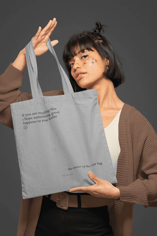 Katoenen tas Something good grijs van Typealive, gedragen met formaat en hengsels duidelijk zichtbaar