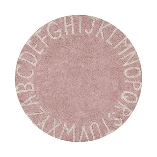 Rond ABC-vloerkleed in oudroze met naturel alfabetletters.